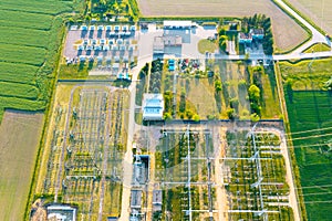Distribution substation in the middle of the field, power plant and many power lines. Aerial view