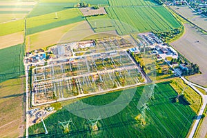 Distribution substation in the middle of the field, power plant and many power lines. Aerial view