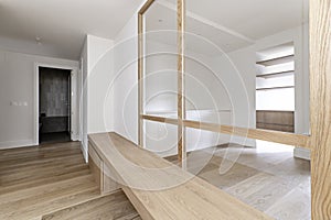 Distributor hallway of a modern home with a long white oak wood bench and a glass and wood screen