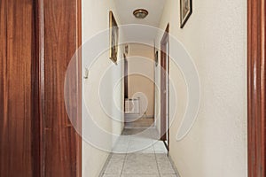 Distributor hallways of a house with light stoneware floors and different sapelly wood doors