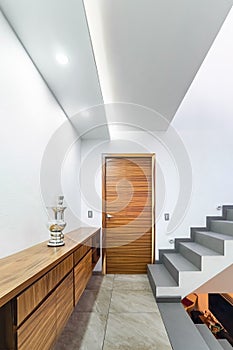 distributor of a modern house, with stairs and light at the foot, wooden storage cabinet, door wood