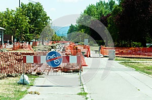 District heating pipeline reparation and reconstruction parallel with the street with construction site safety net fence.