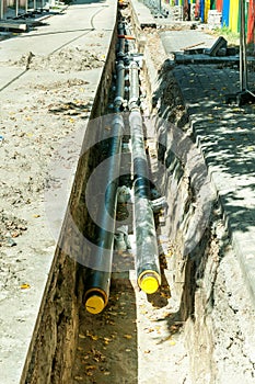 District heating pipeline reparation and reconstruction parallel with the street with construction site safety net fence.