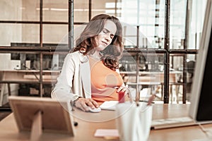 Disturb long-haired woman having movements in her pregnant stomach