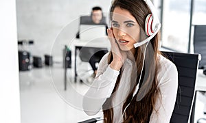 Disturbed female support operator listening carefully client while talking over headset in call center.