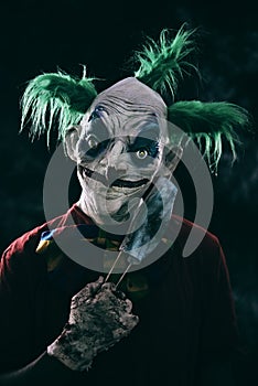 Disturbing evil clown wearing a face mask