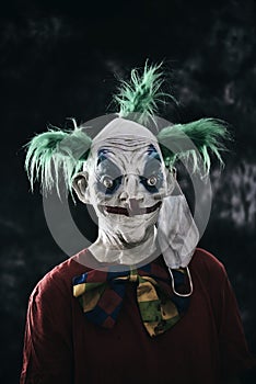 Disturbing evil clown wearing a face mask