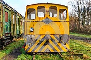 Disused tracks at old station with an old yellow ruined train control cabin