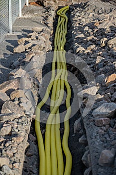 Ditch with yellow utility lines carrying power to electric car chargers..