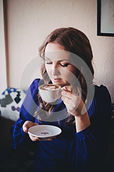 Diva angel mystic lady woman wearing casual blue dress lonely sitting in restaurant caffe with coffe cup awaiting her boyfreind hu