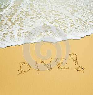 Dive written in a sandy tropical beach