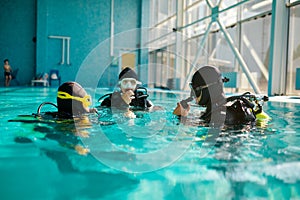 Divemaster and divers in aqualungs, diving school