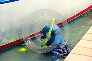 Diver cleaning boat hull maintenance work at dock