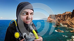 Diver in diving gear, ocean on background