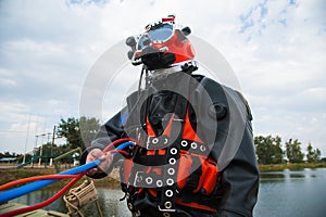Diver in a diving suit and helmet ready to dive