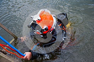 Diver in a diving suit and helmet ready to dive