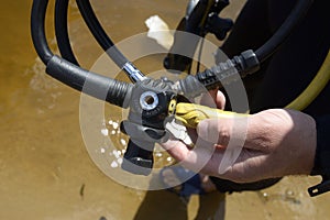 Diver hands holding an air pressure reducer, diving equipment photo