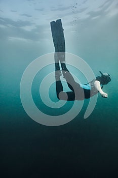 Diver head down in a deep blue dive