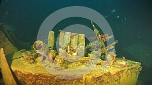 Diver inside hull of sunken ship underwater of Pacific Ocean on Chuuk Islands.