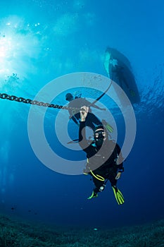 Divers making a decompression stop under their diving boat