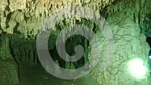 Divers in rocks of underwater cave Yucatan Mexico cenotes.