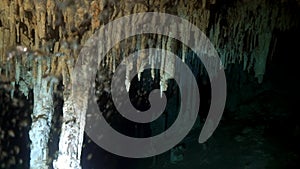 Divers in rocks of underwater cave Yucatan Mexico cenotes.