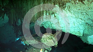 Divers in rocks of underwater cave Yucatan Mexico cenotes.