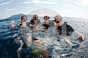 Divers scuba dive together on surface