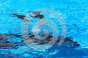 Divers sink in the pool. The teacher teaches the pupil the rules and the lesson of diving.