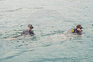 Divers on the surface of water ready to dive