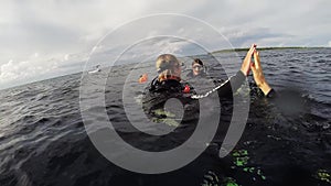 Divers swim in ocean after surfacing from depth. Scubadiving. Happiness.