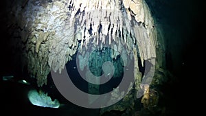 Divers in underwater caves of Yucatan Mexico cenotes.