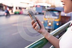 Diverse Asian hipster girl using mobile cell phone in downtown urban city street - Millennial influencer woman holding