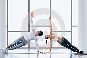 Athletic couple workout  with planking together in gym and fitness center