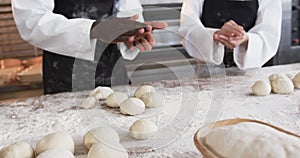 Diverse bakers working in bakery kitchen, making rolls from dough in slow motion