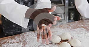 Diverse bakers working in bakery kitchen, making rolls from dough in slow motion