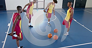 Diverse basketball players practice in an indoor court