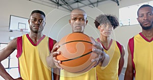 Diverse basketball team poses confidently in the gym