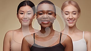 Diverse beauty. Happy african american lady smiling widely to camera, posing with asian and caucasian female friends