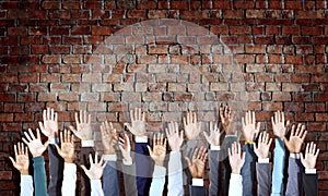 Diverse Business Hands Raised on Brick Wall