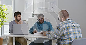 Diverse business partners interviewing job candidate in modern office