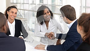 Diverse business partners shaking hands starting collaboration at group negotiations photo