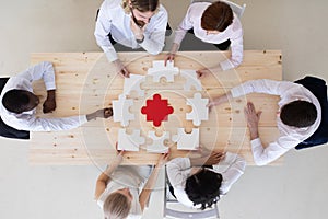 Diverse business people assembling puzzle