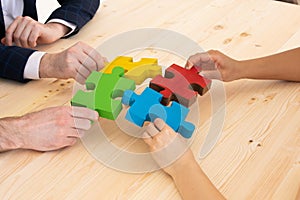 Diverse business people assembling puzzle