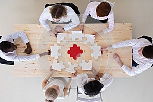 Diverse business people assembling puzzle