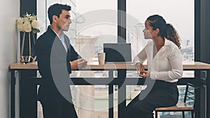 Diverse business people having business conversation during coffee break time with laptop computer and cup of coffee at window