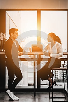 Diverse business people having business conversation during coffee break time with laptop computer and cup of coffee at window