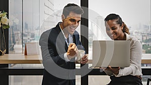 Diverse business people having business conversation during coffee break time with laptop computer and cup of coffee at window