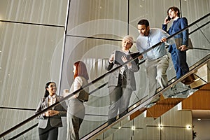 Diverse business professionals descending stairs together.