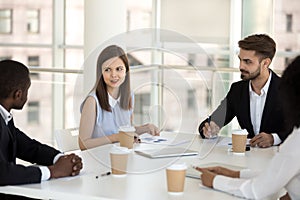 Diverse business team discussing sitting together at meeting